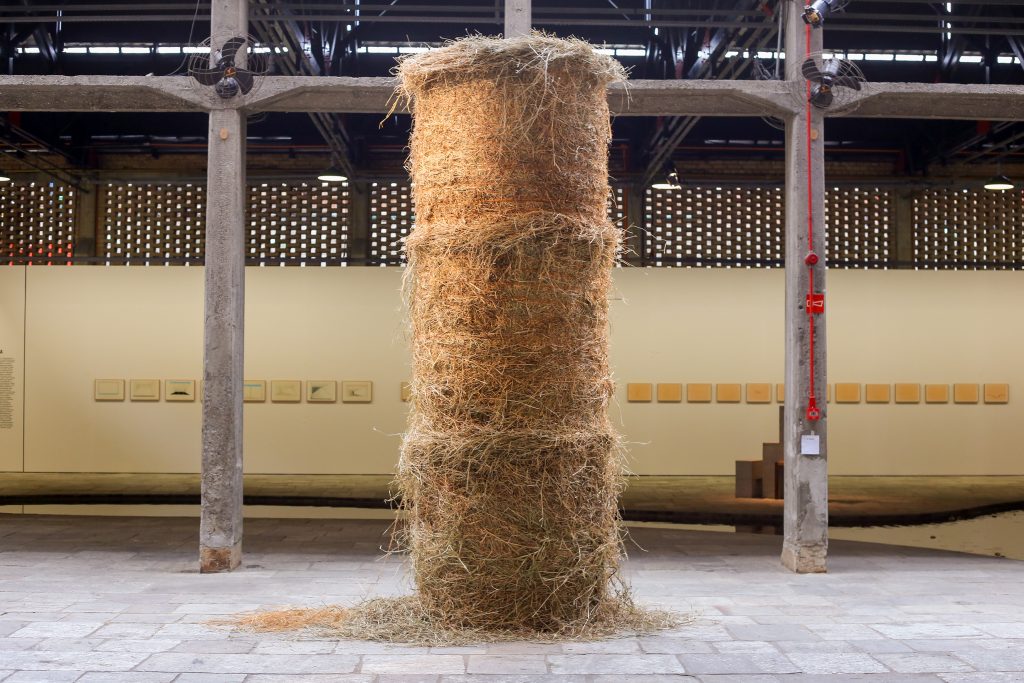 Cildo Meireles, "Fio" (Thread, 1990-1995), golden thread spirals around cylindrical haystack.